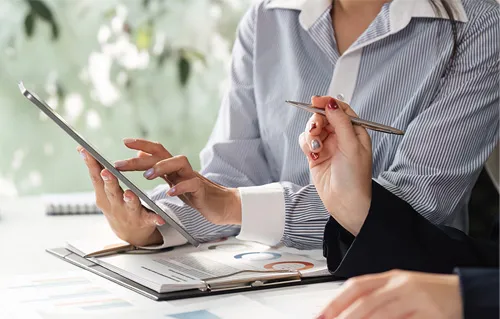 website audit: 2 people with a notebook looking at a table and taking notes